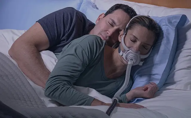 Patientin im Bett mit ihrem airfit f40 von resmed schweiz