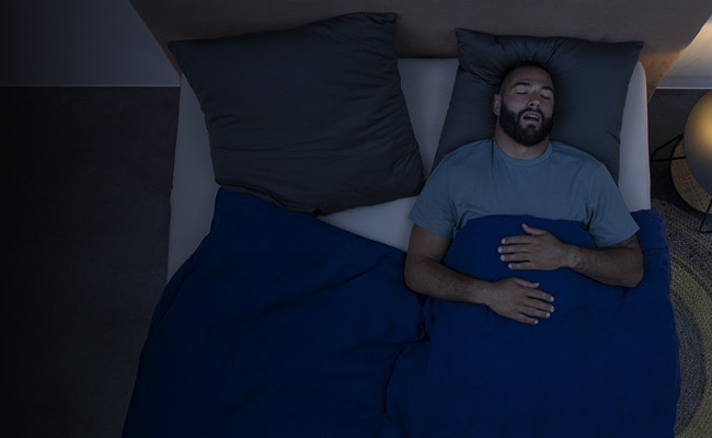 Mann im Bett mit Schlafapnoe
