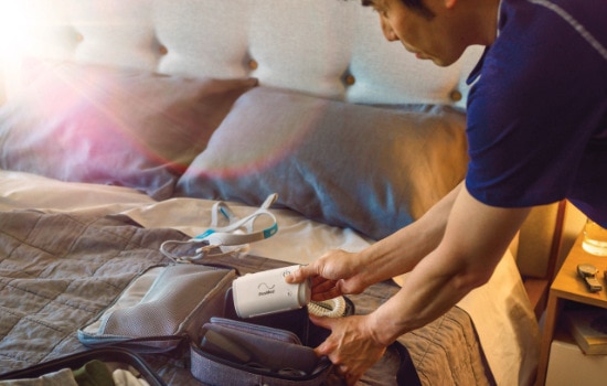 Mann packt AirMini cpap Gerät für eine Reise