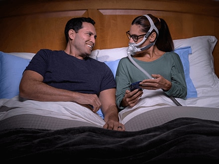 Patientin mit airfit f40-Maske, die ihren Mann anlächelt