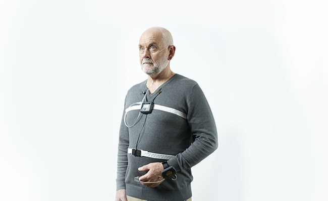 Patient debout avec un appareil de diagnostic d'apnée du sommeil de ResMed Suisse