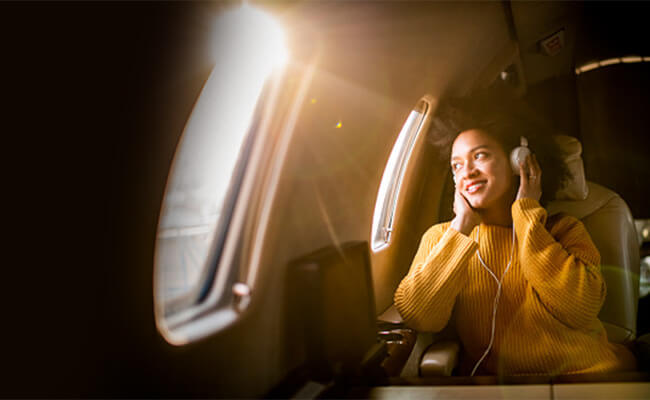 femme en avion avec sa CPAP de voyage AirMini ResMed